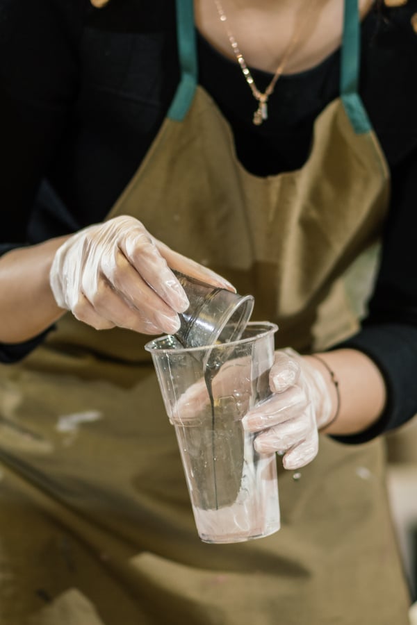 work on a workshop to create resin art. liquid resin is poured from glass to glass